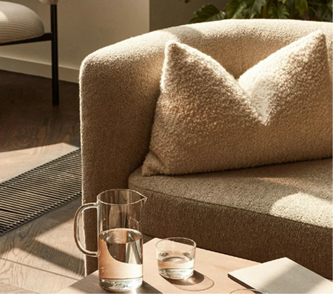 Sofá de textura natural con mesa auxiliar y cristalería